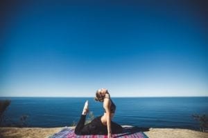 Girl doing yoga on the seaside